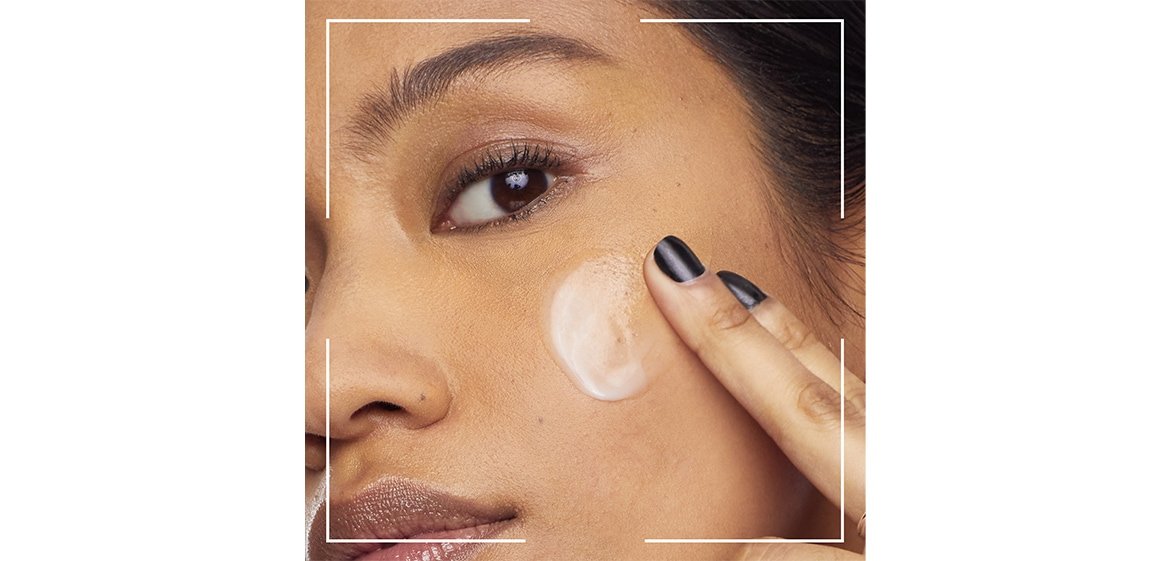 Ein Frau trägt Make-up auf ihre Wange auf